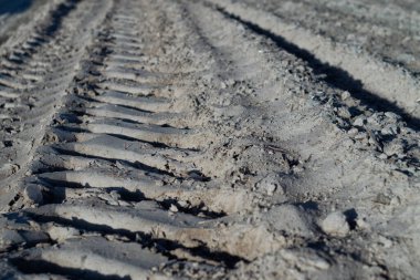 Büyük bir lastik izinden toprak yolda bir iz.