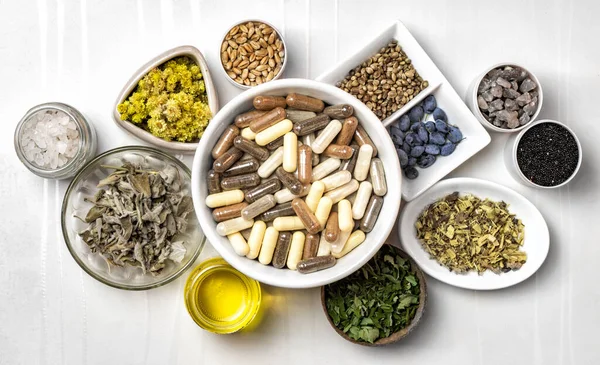 Bitkisel ve mineral organik besin maddeleri kapsüllerde. Tabaklardaki gıda takviyeleri için gerekli malzemeler