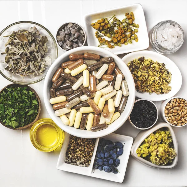 Bitkisel ve mineral organik besin maddeleri kapsüllerde. Tabaklardaki gıda takviyeleri için gerekli malzemeler