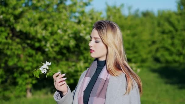 Portrait of young lovely woman in spring flowers — Stock Video