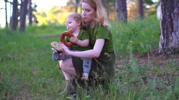 Mom and child in the forest eating bread — Stock Video