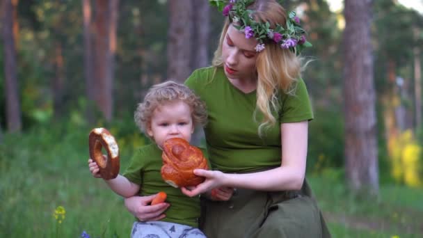 Mom and child in the forest eating bread — Stock Video