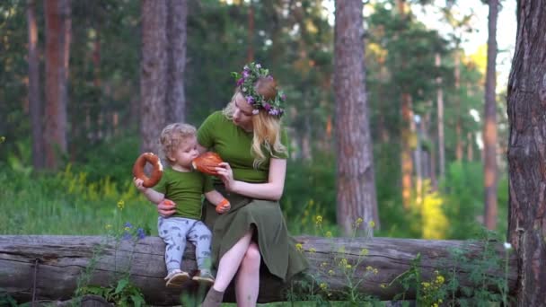 Mom and child in the forest eating bread — Stock Video