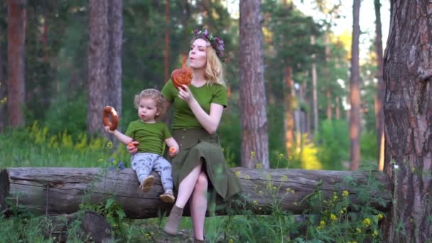 Mom and child in the forest eating bread — Stock Video