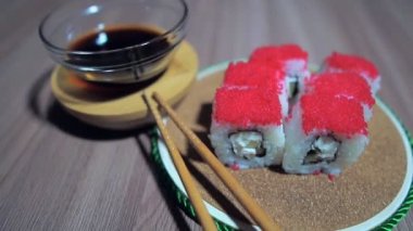 Tahtada bambu çubuklarıyla rulo servis edilir.