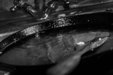 Bulaşıkları yıkıyor. Lavaboda pan.