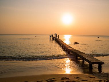 Gün batımında rıhtımdaki insanlar. Phu Quoc adasında, Vietnam 