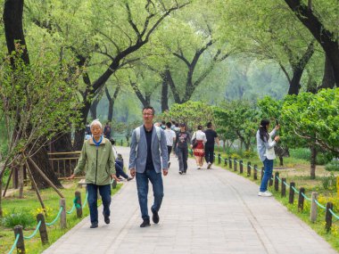 Pekin, Çin - 5 Mayıs 2024: Kunming Gölü yakınlarındaki Yaz Sarayı kompleksinde yürüyen insanlar.