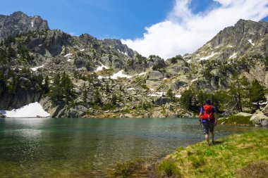 Aiguestortes Milli Parkı ve göl San Mauricio bir gölün yanında yürüyen adam