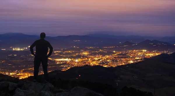 Homme Tient Sommet Une Montagne Sur Fond Lumières Ville Nocturne — Photo