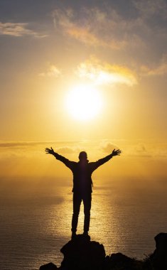 silhouette achievements successful arm up man is on top of hill celebrating success with sunrise over the sea, Basque Country, Spain clipart