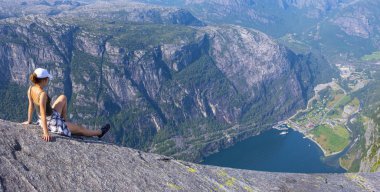 Norveç'te Lysefjord üzerinde manzara hayran oturan kız