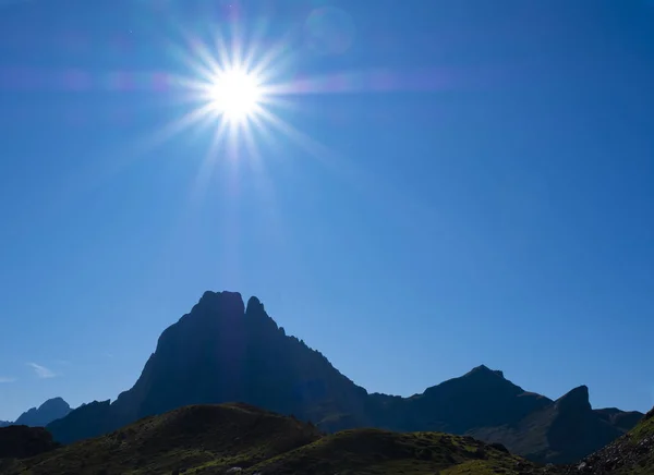 The sun over the Midi d\'Ossau peak in the Pyrenees National Park, France