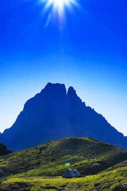 Midi d'Ossau ve Pireneler Milli Parkı arka planda güneş ile kamp çadırı, Fransa