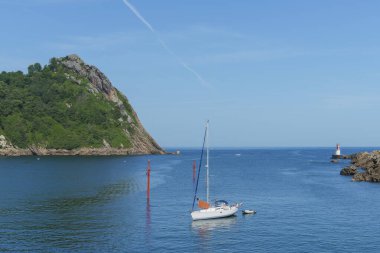 Arka planda La Plata deniz feneriyle Pasaia Körfezi 'ne demir atmış bir yelkenli.
