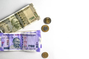 500 ve 100 rupi şeklinde Hint para birimi, para ve finansal kaynak kavramını gösteren beyaz bir zemin üzerinde düzgün bir şekilde sergilenen bozuk paraların yanı sıra.
