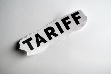 Kağıda basılmış, vurgu için yırtılmış 'Tariff' kelimesinin yakın plan görüntüsü.