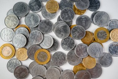 Karışık mezheplerde bir dizi Hint sikkesi, metalik dokular ve tasarımlar sergileniyor, para ve finans birimlerini temsil ediyor..