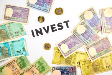 Yatırım ve ekonomik büyümeyi sembolize eden, yatırım sözcüğü etrafında düzenlenmiş Hint para ve para birikimleri koleksiyonu.