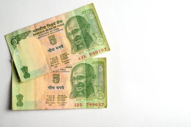 Basit bir ışık yüzeyinde karmaşık tasarımlar ve kültürel öneme sahip iki Hintli beş rupi bir araya getirilmiş..