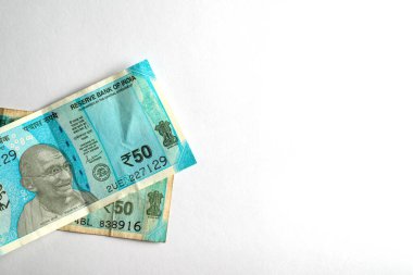 Finans ve ekonomiyi temsil eden, beyaz bir arkaplanda sergilenen iki Hint 50 rupisinin yakın plan görüntüsü.