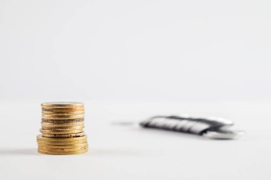 Beyaz bir yüzeye saçılmış gümüş sikkeler ile temiz bir yığın altın sikke, finansal büyüme, iş stratejisi ve parasal başarı kavramlarını vurguluyor.