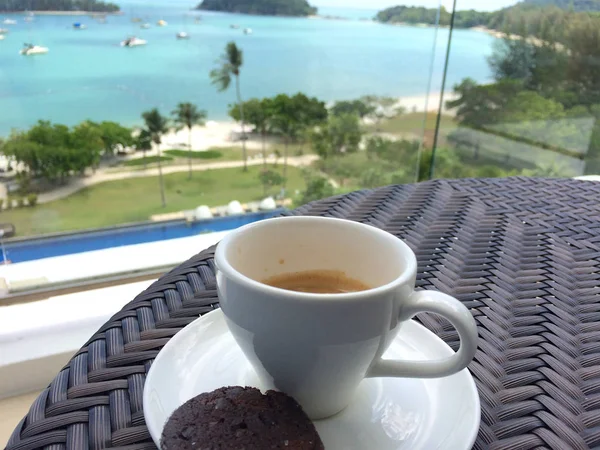 Pulau langkawi, malaysien - 4. Apr 2015: eine Tasse Kaffee und Kekse auf einem Tisch mit Meer im Hintergrund — Stockfoto