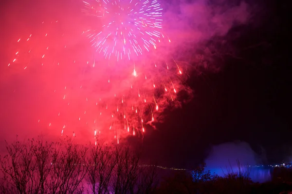 NIAGARA FALLS, ONTARIO, CANADA - 20 de maio de 2018: Cataratas do Niágara iluminadas à noite por luzes coloridas com fogos de artifício — Fotografia de Stock