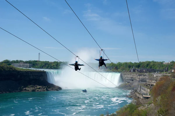 Niagara Falls, Ontario, Kanada - 21st Mayıs 2018: arka planda Horseshoe Falls ile yaz aylarında, Niagara Şelalesi'nde zipline yolculuğu alarak iki kişi
