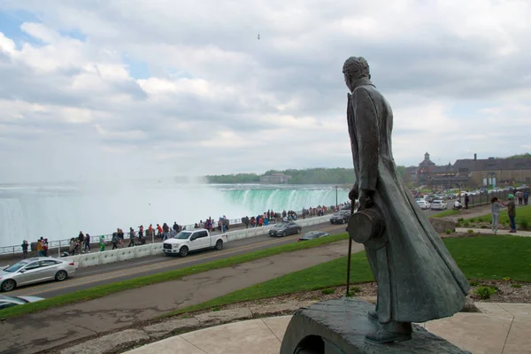 Niagara Falls, Ontario, Kanada - 21st Mayıs 2018: Nikola Tesla'nın heykel Kraliçe Victoria Park ile arka planda Horseshoe falls.