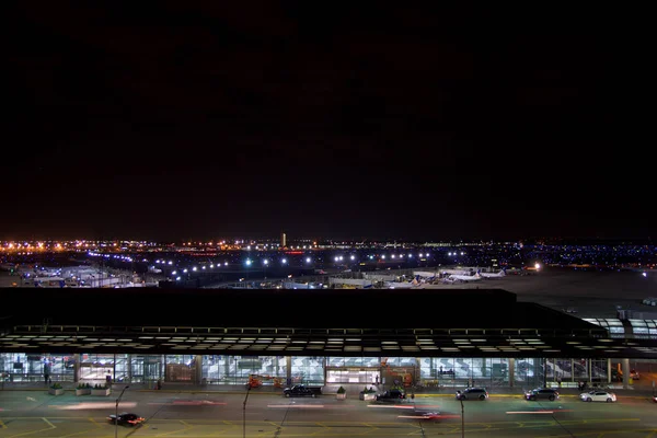 CHICAGO, ILLINOIS, ESTADOS UNIDOS - 11 de maio de 2018: Fora do Aeroporto Internacional de Chicago OHare à noite com alguns carros e aviões no terminal — Fotografia de Stock