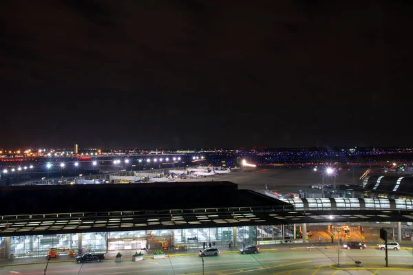 CHICAGO, ILLINOIS, ESTADOS UNIDOS - 11 de maio de 2018: Fora do Aeroporto Internacional de Chicago OHare à noite com alguns carros e aviões no terminal — Fotografia de Stock