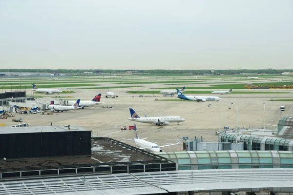 Chicago, Illinois, Stany Zjednoczone-11 maja 2018: kilka linii lotniczych jet parking na pozycji bramki na lotnisku Chicago Ohare rano — Zdjęcie stockowe