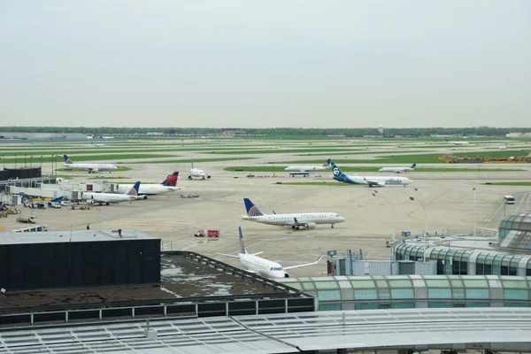 Chicago, Illinois, USA - 11 maj 2018: flera flygbolag jet parkering vid gate position på den internationella flygplatsen Chicago Ohare på morgonen — Stockfoto