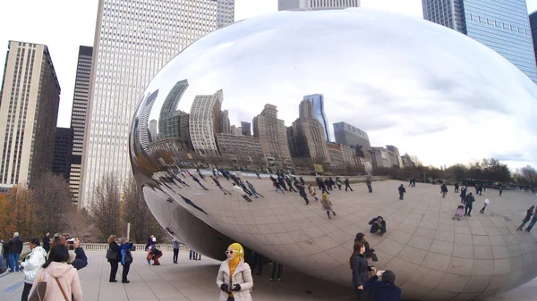CHICAGO, ILLINOIS, ESTADOS UNIDOS - DEC 12th, 2015: O horizonte de Chicago através do famoso monumento Cloud Gate no Millennium Park com uma multidão de pessoas durante o inverno — Fotografia de Stock