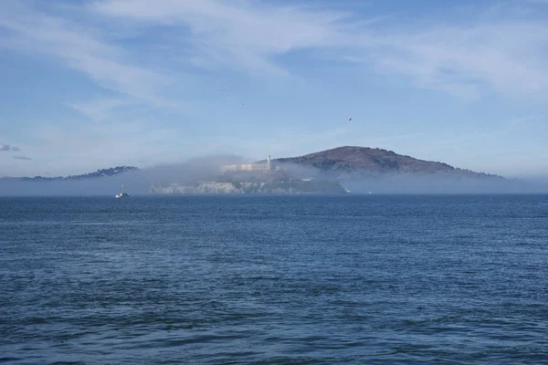 SAN FRANCISCO, CALIFORNIA, ESTADOS UNIDOS - 25 DE NOV DE 2018: Prisión de Alcatraz en panorama de niebla durante un día soleado de noviembre visto desde el muelle 39 — Foto de Stock