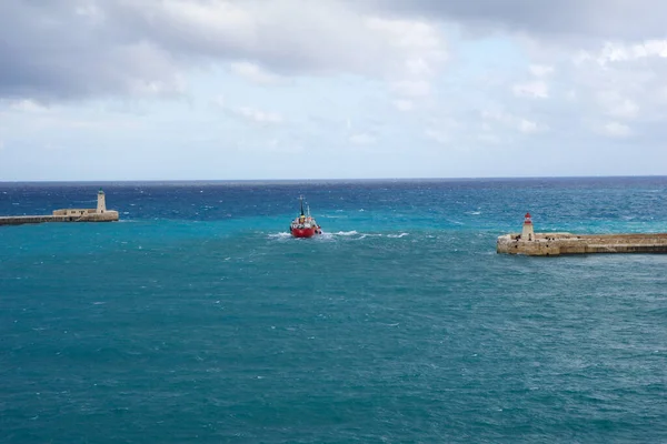 VALLETTA, MALTA - 31 DEC 2019: kırmızı ve yeşil fener iskele ışığı Fort St Elmo 'dan Grand Harbour Valletta Malta liman girişinde kırmızı gemiyle görüntülenir