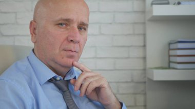 İşadamı Görüntü Yöneticisi sandalyeden kameraya bakarak sakin bir tutum ile