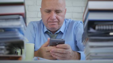 Üzgün ve hayal kırıklığına işadamı okuma cep telefonu mesaj oda ofis içinde