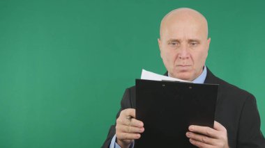 Ciddi iş adamı görüntü okuma belgeleri ile yeşil ekran arka planı