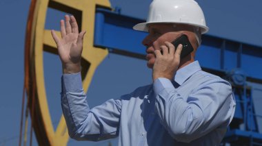 Petrol konuşup mobil el hareketi ayıklama çalışan petrol mühendisi