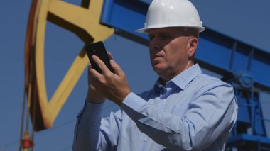 Mobil kullanarak petrol sanayi metin ayıklama çalışan petrol mühendisi