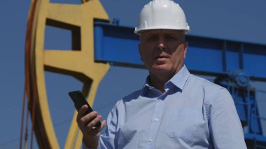 Cep telefonu ile konuşurken petrol endüstrisinin ayıklama çalışan petrol mühendisi