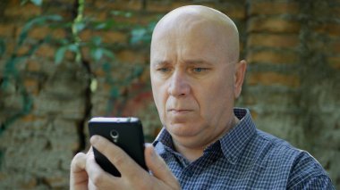 Cep telefonuna hayal kırıklığına yüzü olan dalgın görünen adam