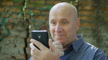 Mutlu işadamı gülümseme cep telefonuyla mali iyi haber okuma memnun