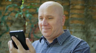 Hevesli işadamı gülümseme mutlu okuma iyi finansal haber üstünde hareket eden telefon