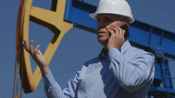 Petroleum Engineer Working in Extracting Oil Talk to Mobile and Gesturing