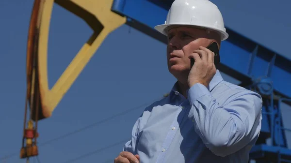 Petroleum Engineer Working in Extracting Oil Industry Talking to Mobile Phone