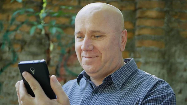 Hevesli işadamı gülümseme mutlu okuma iyi finansal haber üstünde hareket eden telefon