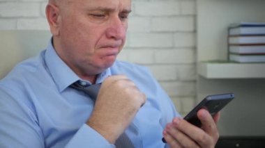 Yorgun ve üzgün bir işadamı cep telefonu bir finansal kötü haberleri okuyun